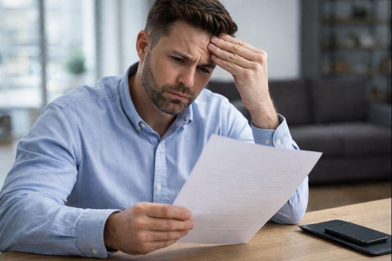 Job applicant reviewing an employment and criminal background check report with concerned expression