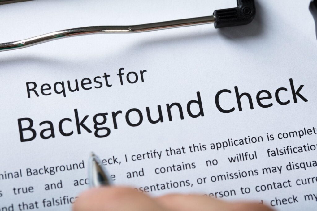 Concerned tenant reviewing housing background report with rental documents on a desk